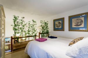 a bedroom with two beds and paintings on the wall at PRETTY DUPLEX IN BOHEMIAN DISTRICT-CITY CENTER in Seville