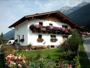 a white house with flowers on the side of it at Ferienwohnung Haas Maria in Neustift im Stubaital