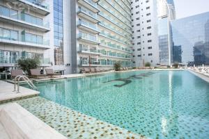 a large swimming pool in a building with tall buildings at Staycae Holiday Homes - Majestine in Dubai