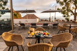 una mesa con una bandeja de comida en el patio en 1905 Zino's Palace en Ponta do Sol