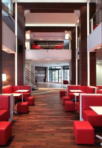 une salle à manger avec des chaises et des tables rouges dans l'établissement Hôtel Le Méditerranée, à Lourdes