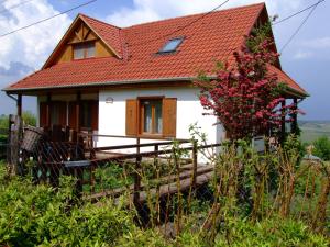 uma pequena casa branca com um telhado vermelho em Kaláris Vendégház em Hollókő