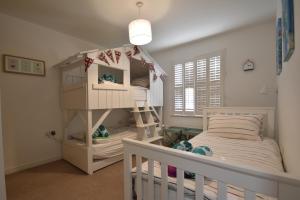 Habitación infantil con litera y cuna en Strand House, en Camber