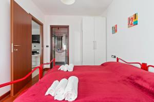 a red bed with white towels on top of it at Milano-Rubattino Budget Apartment in Milan