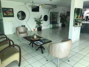 a living room with chairs and a table in a room at Hotel Cabana in Teresina