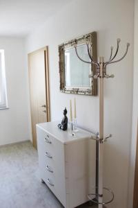 W łazience znajduje się umywalka, lustro i świeca. w obiekcie Dachterrassen Appartement Monte Lupo w mieście Wolfsberg