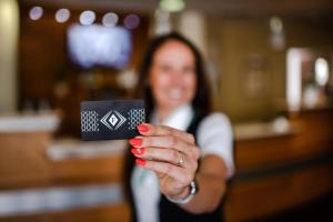 a woman holding up a black box with a pentagram at Hotel Famulus in Győr