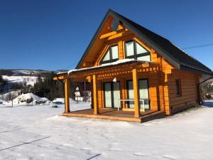 a log cabin with snow on the ground at Miętusowa Chata pod Babią in Zawoja