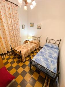 - une chambre avec 2 lits et un sol en damier dans l'établissement Grillo apartment, à Levanto