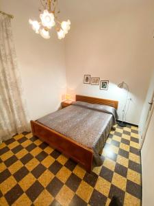 - une chambre avec un lit et un sol en damier dans l'établissement Grillo apartment, à Levanto