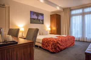a hotel room with a bed and a desk at De Zwaan Delden in Delden +34 photos