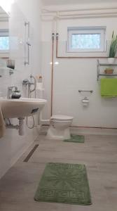 La salle de bains est pourvue d'un lavabo, de toilettes et d'une fenêtre. dans l'établissement Kovács Vendégház, à Mátraderecske