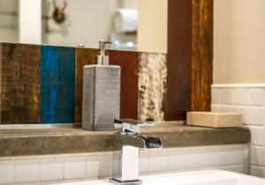 a bathroom sink with a faucet and a mirror at The Waverley Park Residence in Edinburgh +27 photos
