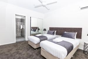 a bedroom with two beds and a shower at Wagga Apartments #1 in Wagga Wagga
