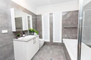 a bathroom with a tub and a toilet and a sink at Wagga Apartments #1 in Wagga Wagga
