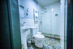 a white bathroom with a toilet and a sink at Home 12 in Tbilisi City