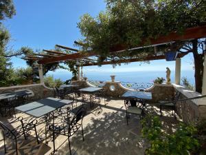 a patio with tables and chairs under a pergola at B&B Miramare in Agerola