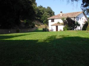 a green lawn with a table in front of a house at Allotjaments Mas Rafalot in Bas