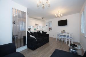 Seaesta Apartments في Macduff: غرفة معيشة مع أريكة وطاولة
