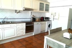 ヴィラ・ノヴァ・デ・ミルフォンテスにあるCasa Marecoの白いキャビネット、シンク、食器洗い機付きのキッチンが備わります。