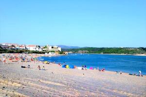 a group of people on a beach near the water at Casa Mareco in Vila Nova de Milfontes