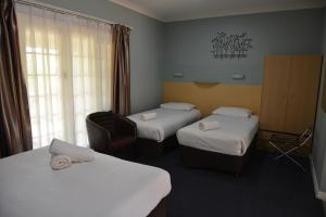 A bed or beds in a room at Poplars Inn Mittagong