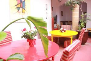 een tafel met een plant en een gele tafel en stoelen bij Riad Haizea Mogador in Essaouira