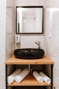 La salle de bains est pourvue d'un lavabo noir et d'un miroir. dans l'établissement Boutique Hotel Nea, à Brčko