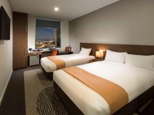 A bed or beds in a room at ibis Brisbane Airport
