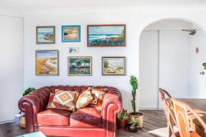 a living room with a red leather couch at OMG Beach View Penthouse by Sydney Dreams in Sydney