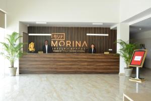a lobby with people standing at a reception desk at TreeHouse Morina, Vithalapur in Vithalpur +20 photos