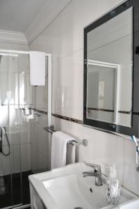 a white bathroom with a sink and a mirror at Casa de Ross in Pretoria