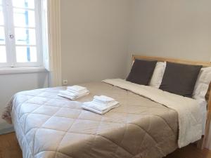 a bedroom with a large bed with towels on it at Queen's Garden Hostel in Porto