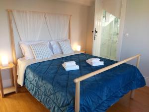 um quarto com uma cama grande e toalhas em Queen's Garden Hostel no Porto