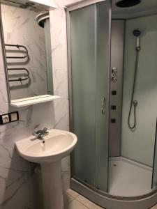 a bathroom with a sink and a shower at LUXflats Rivne in Rivne +17 photos
