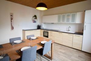uma cozinha com uma mesa de madeira com cadeiras e um lavatório em Fantastic Apartment in Enchanting Neighbourhood em Ludwigshafen am Rhein