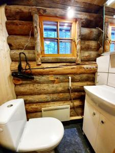 a bathroom with a white toilet and a wooden wall at Kieppi in Syöte +36 photos