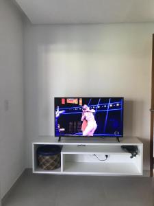 a flat screen tv sitting on a white entertainment center at Village Areias de Itacimirim in Itacimirim +7 photos