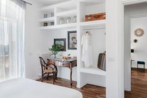 a white bedroom with a desk and a bed at Angolo del poeta suite in Matera