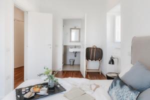 a white living room with a tray of food on a bed at Angolo del poeta suite in Matera