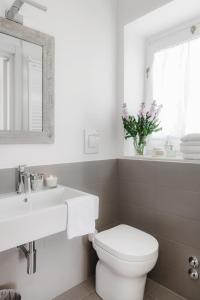bagno con servizi igienici, lavandino e specchio di Angolo del poeta suite a Matera