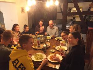 a group of people sitting around a table eating food at Duplex Saint Lustre, view over castle and storks, 5 mn from Colmar in Eguisheim