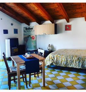 a bedroom with a bed and a table and a dining room at Casetta Gialla in Giaveno