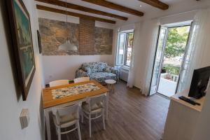 a living room with a table and chairs and a couch at Apartman Hrabrić 2 in Njivice