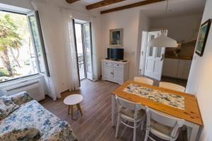a kitchen and dining room with a table and chairs at Apartman Hrabrić 2 in Njivice +8 photos