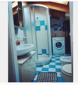 a bathroom with a sink and a washing machine at Casetta Gialla in Giaveno