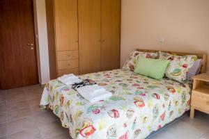 - une petite chambre avec un lit doté d'un couvre-lit fleuri dans l'établissement Lovely Apartment Next to the Sea Lygia Korinthias, à Liyiá