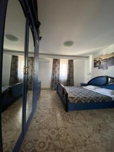 Cette chambre comprend 2 lits et un miroir. dans l'établissement Motel Valentina, à Ion Roată