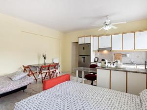 a living room with two beds and a kitchen at Homely Apartment in Piraeus with Balcony in Athens