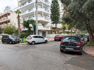 a parking lot with cars parked in front of a building at Homely Apartment in Piraeus with Balcony in Athens